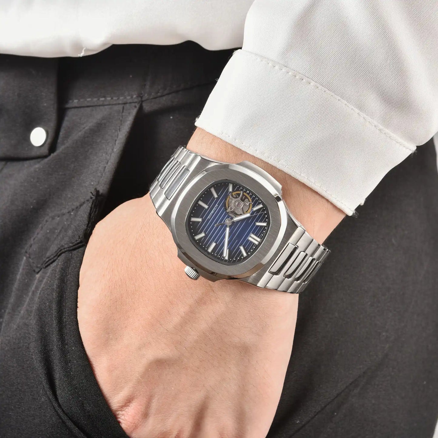 Men's blue open heart dial Nautilus style Seiko mod watch on wrist, casual daily wear lifestyle shot