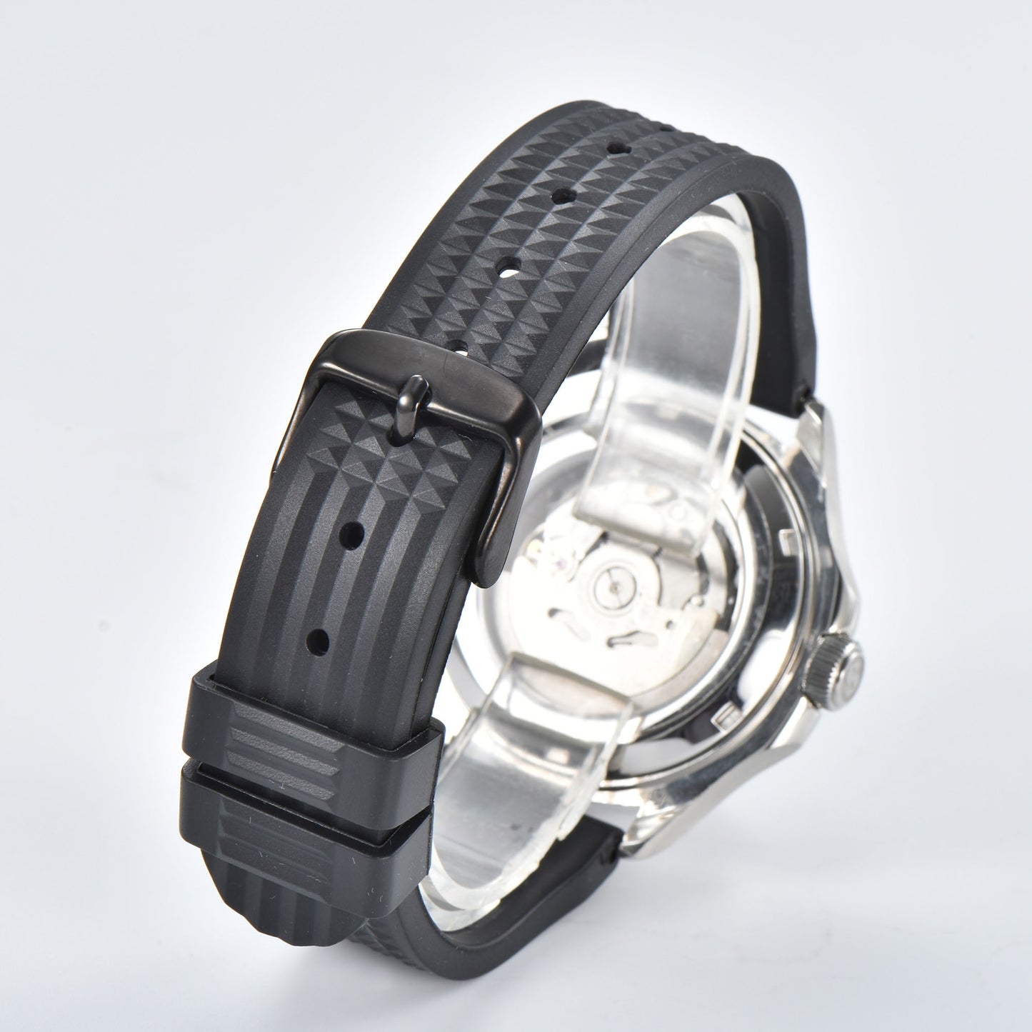Transparent case back and pin buckle of silver Aquanaut style Seiko mod watch with black rubber strap