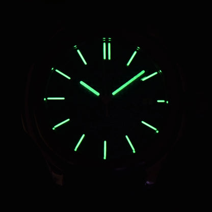 Low light close-up of Seiko mod watch dial showing strong C3 Super-LumiNova on custom hands and indices