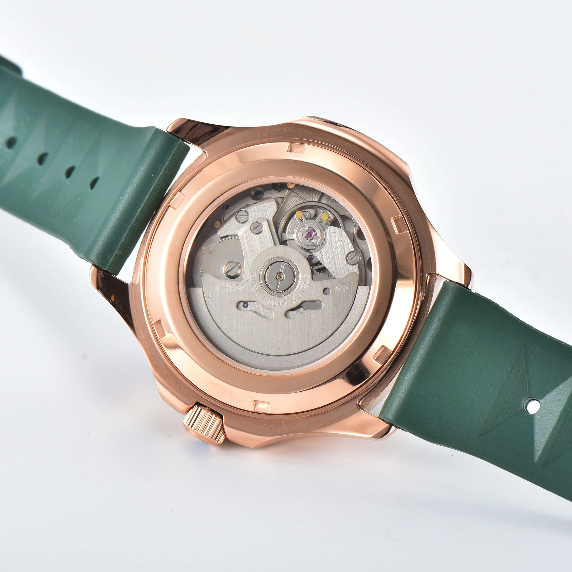 Clear case back showing Seiko NH35 automatic movement in rose gold green Aquanaut style Seiko mod watch