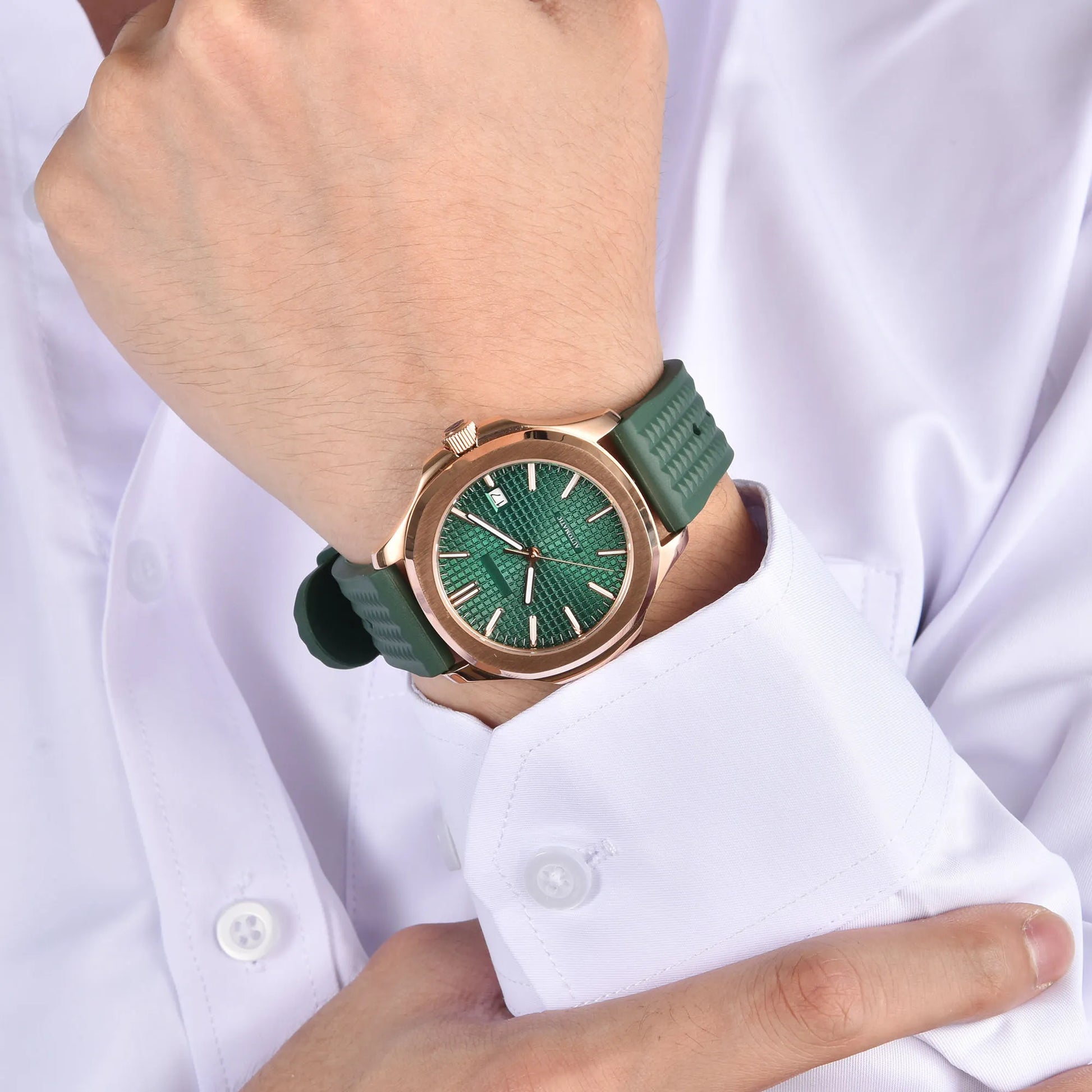 Rose gold Aquanaut style Seiko mod watch with green rubber strap on wrist, business lifestyle shot