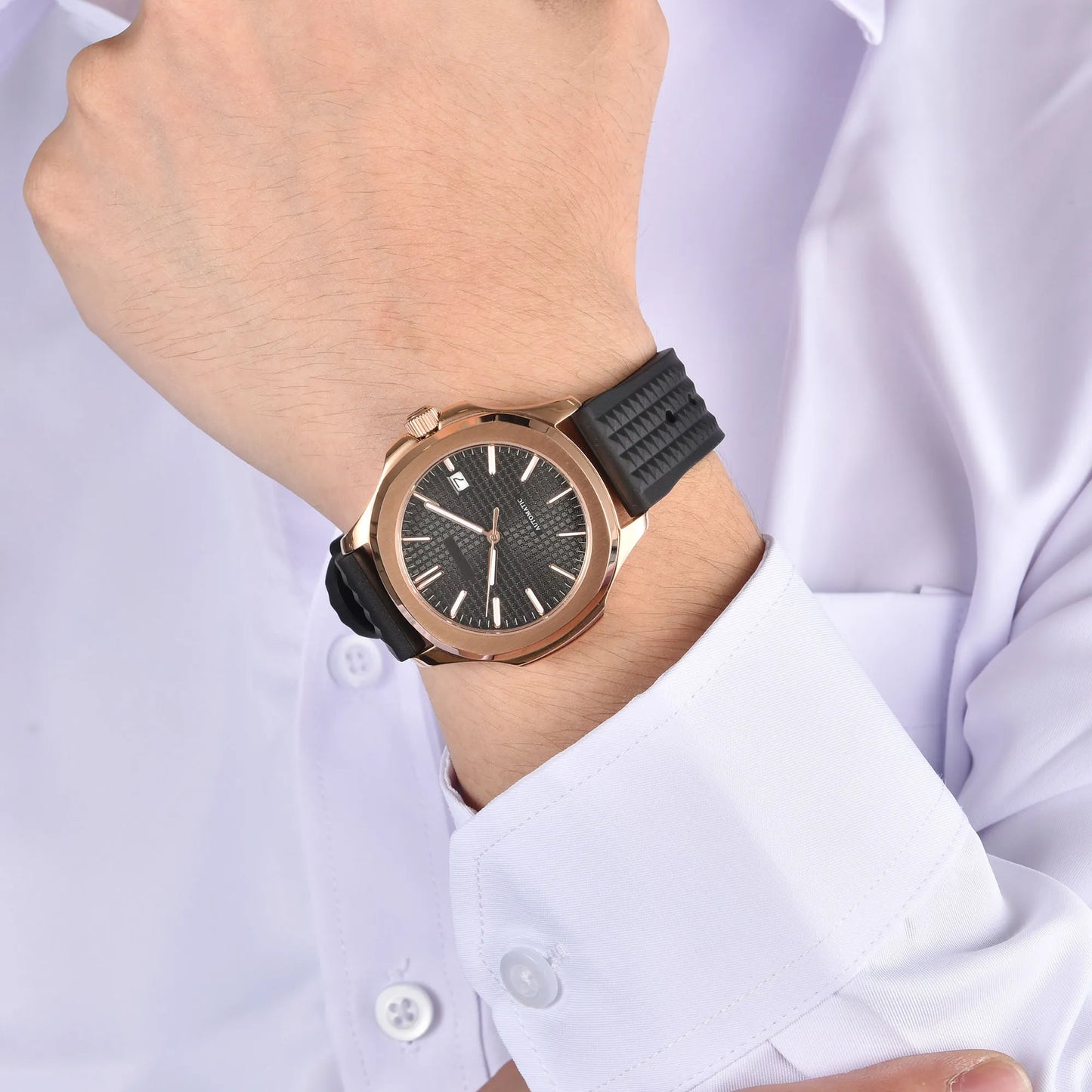 Rose gold Aquanaut style Seiko mod watch with black rubber strap on wrist, business lifestyle shot