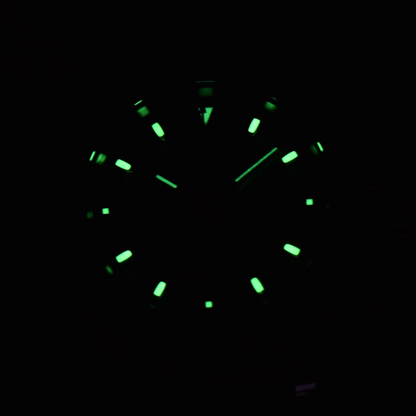Luminous green hands and dial of panda VK63 Daytona style Seiko mod chronograph watch in dark environment