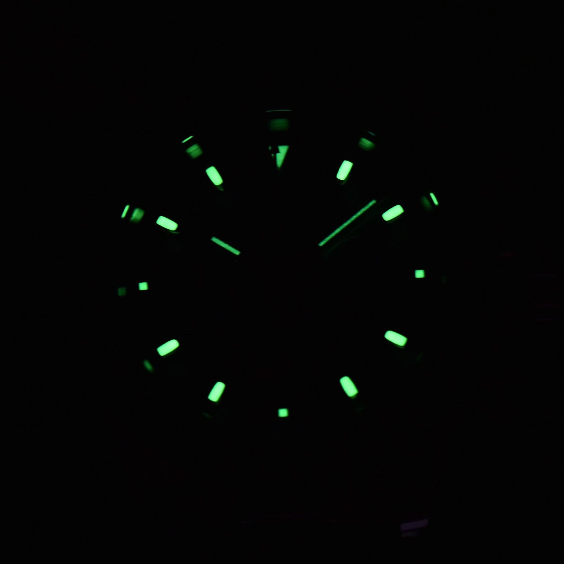 Luminous green hands and dial of panda VK63 Daytona style Seiko mod chronograph watch in dark environment