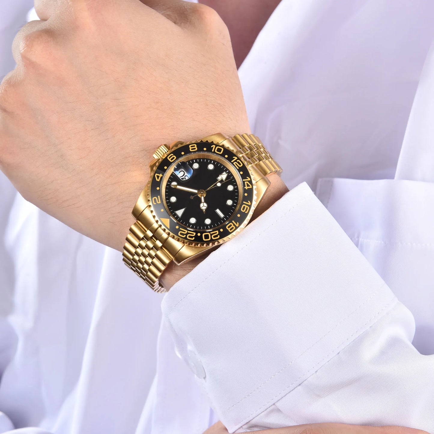Wrist shot of custom Seiko nh34 GMT mod watch with sapphire crystal gold case and lumen black dial