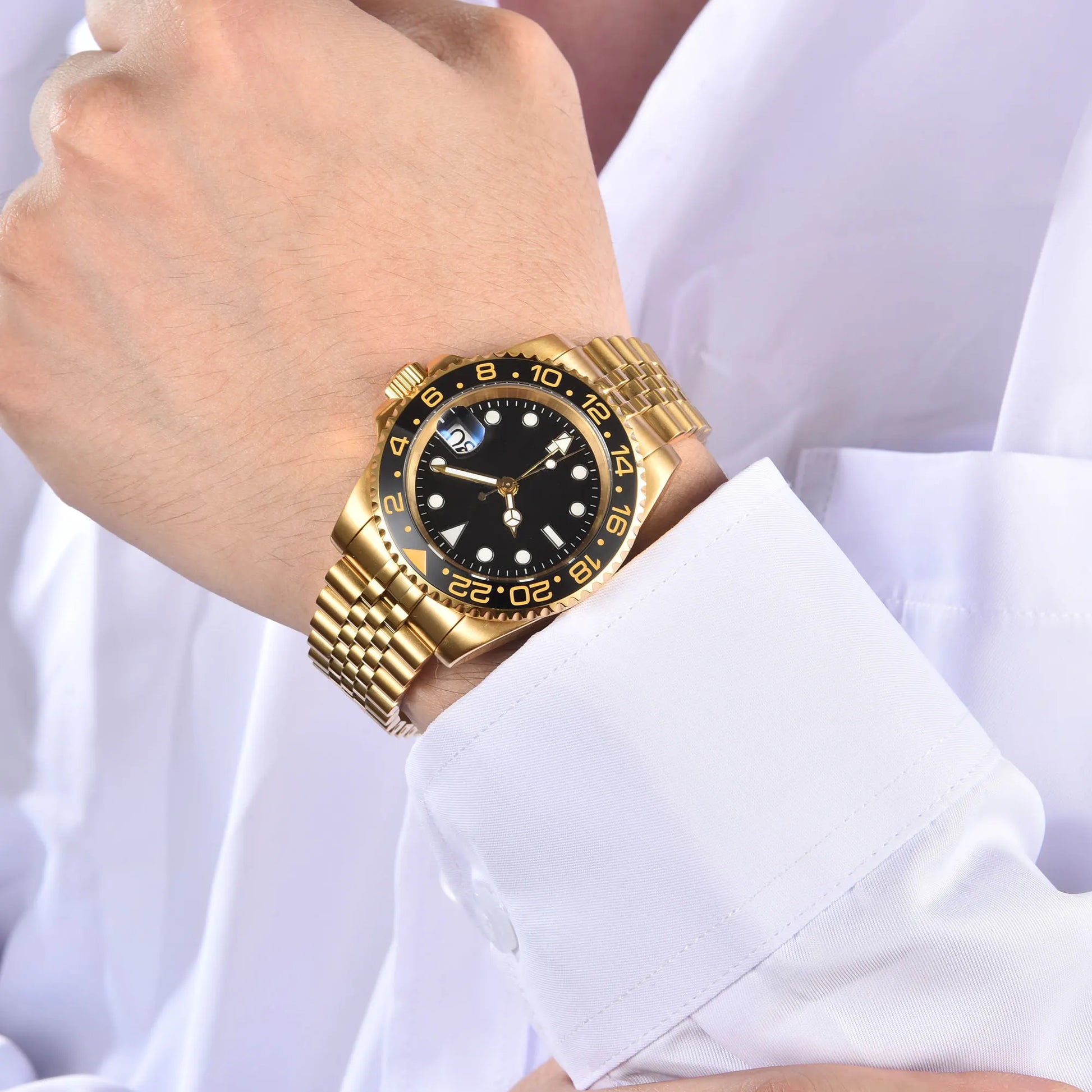 Wrist shot of custom Seiko nh34 GMT mod watch with sapphire crystal gold case and lumen black dial