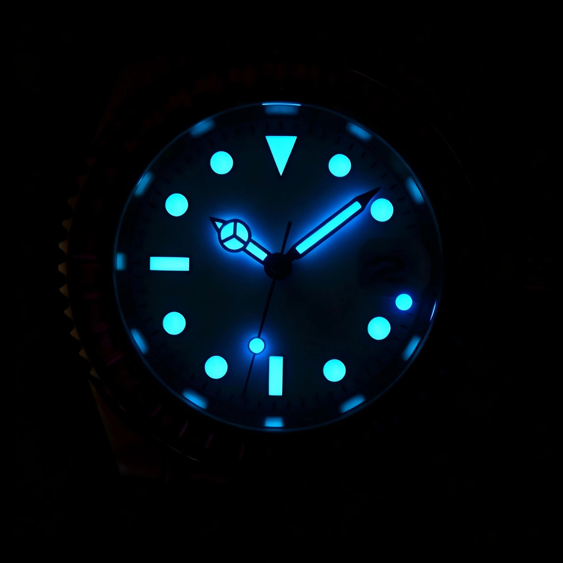 Low light close-up of Seiko mod watch hands showing strong blue Super-LumiNova