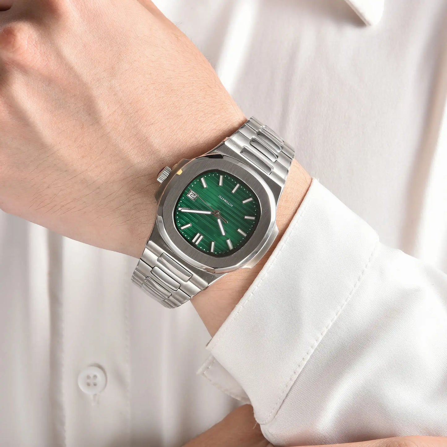 Green dial Nautilus style Seiko mod watch with stainless steel bracelet on wrist, business lifestyle shot
