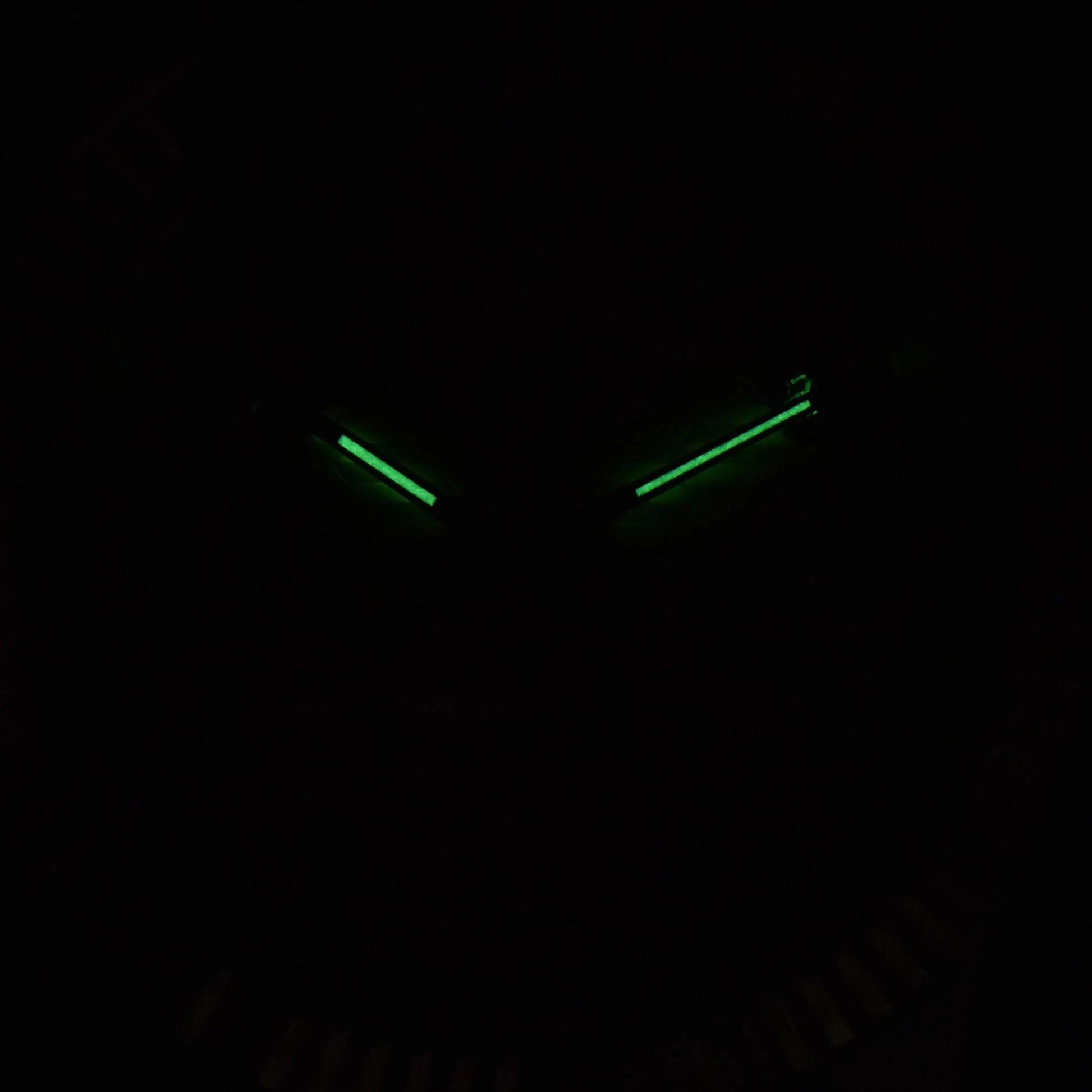 Low light close-up of Seiko mod watch hands showing strong C3 Super-LumiNova 