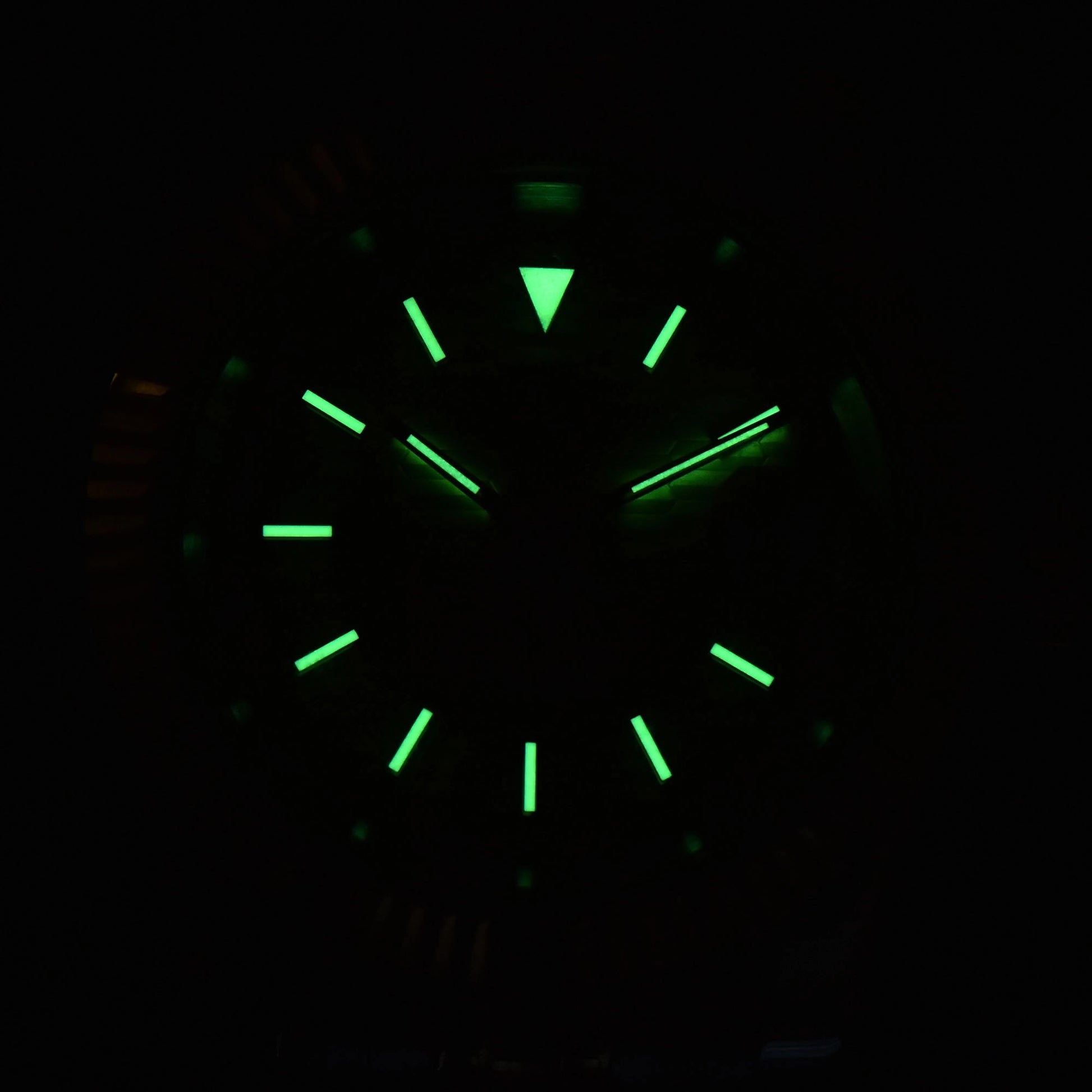 Low light close-up of Seiko mod watch dial showing strong C3 Super-LumiNova on custom hands and indices