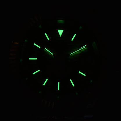 Low light close-up of Seiko mod watch dial showing strong C3 Super-LumiNova on custom hands and indices