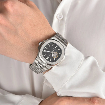 Open heart black Nautilus style Seiko mod watch with stainless steel bracelet on wrist, business lifestyle shot