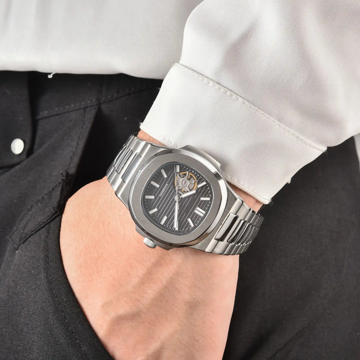 Men's black open heart dial Nautilus style Seiko mod watch on wrist, casual daily wear lifestyle shot