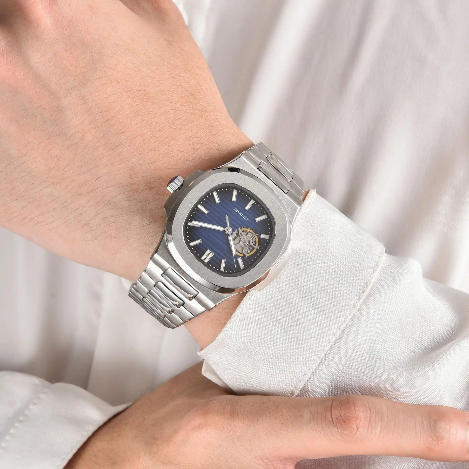 Open heart blue Nautilus style Seiko mod watch with stainless steel bracelet on wrist, business lifestyle shot