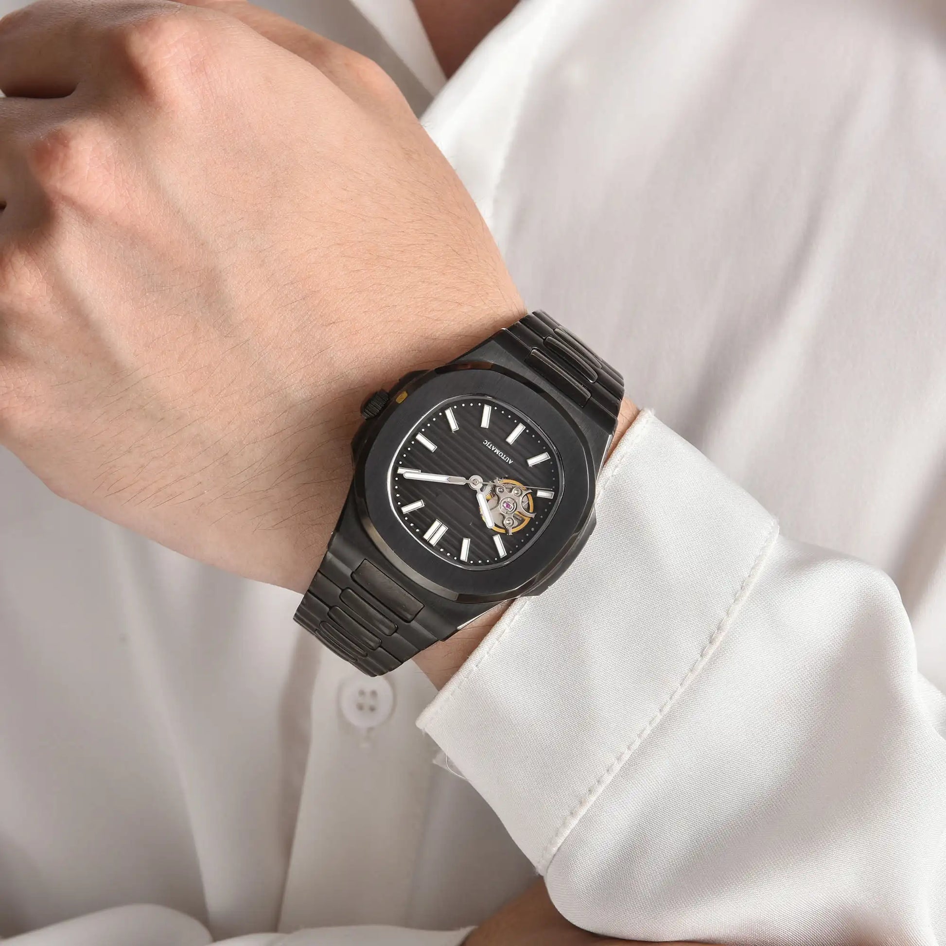 Open heart Nautilus style Seiko mod watch with stainless steel bracelet on wrist, business lifestyle shot