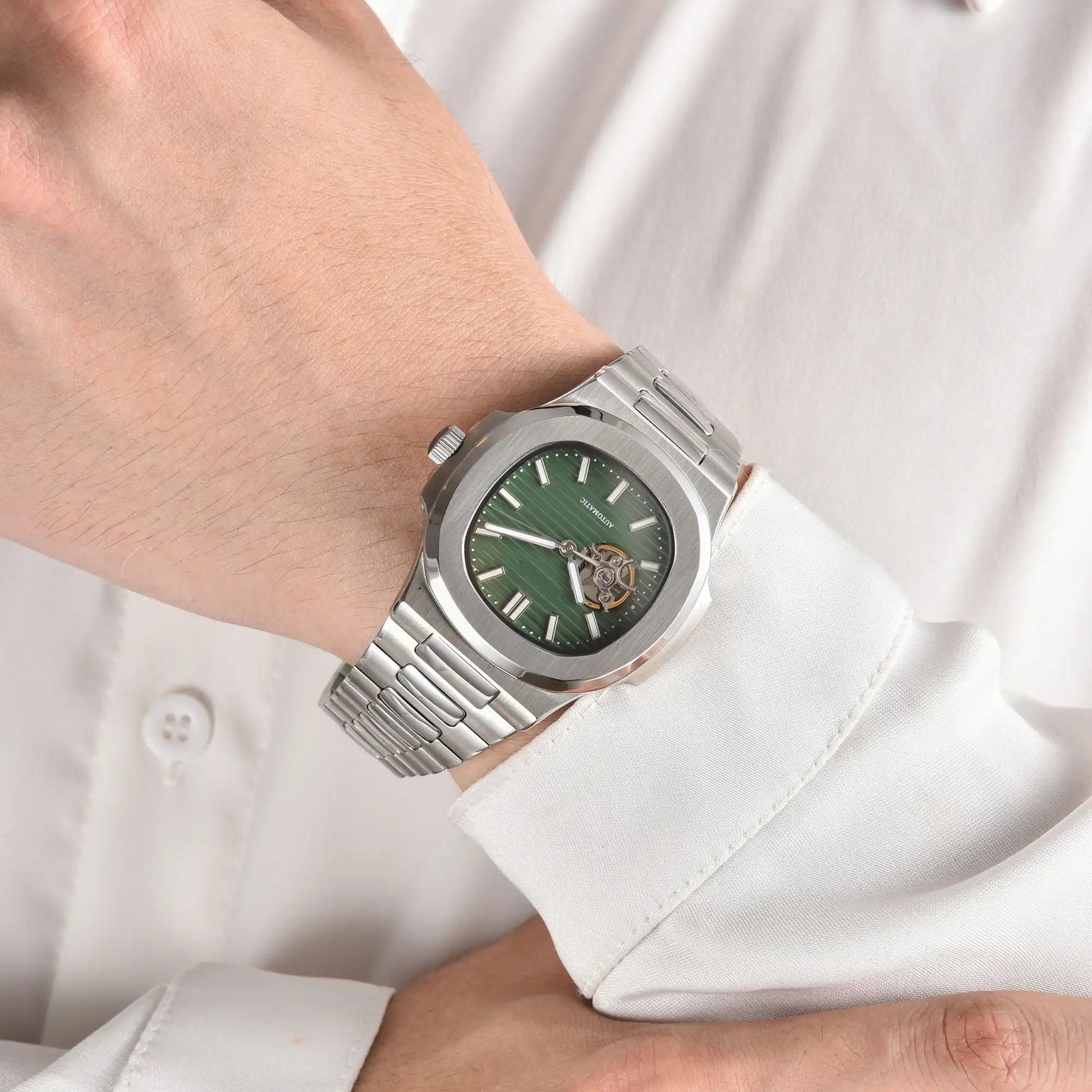 Open heart green Nautilus style Seiko mod watch with stainless steel bracelet on wrist, business lifestyle shot