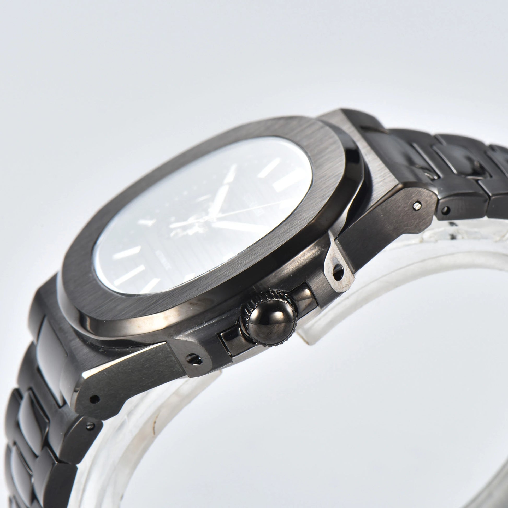 Side view of open heart Nautilus style Seiko mod watch, polished stainless steel case and black crown detail