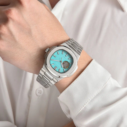 Open heart tiffany blue Nautilus style Seiko mod watch with stainless steel bracelet on wrist, business lifestyle shot