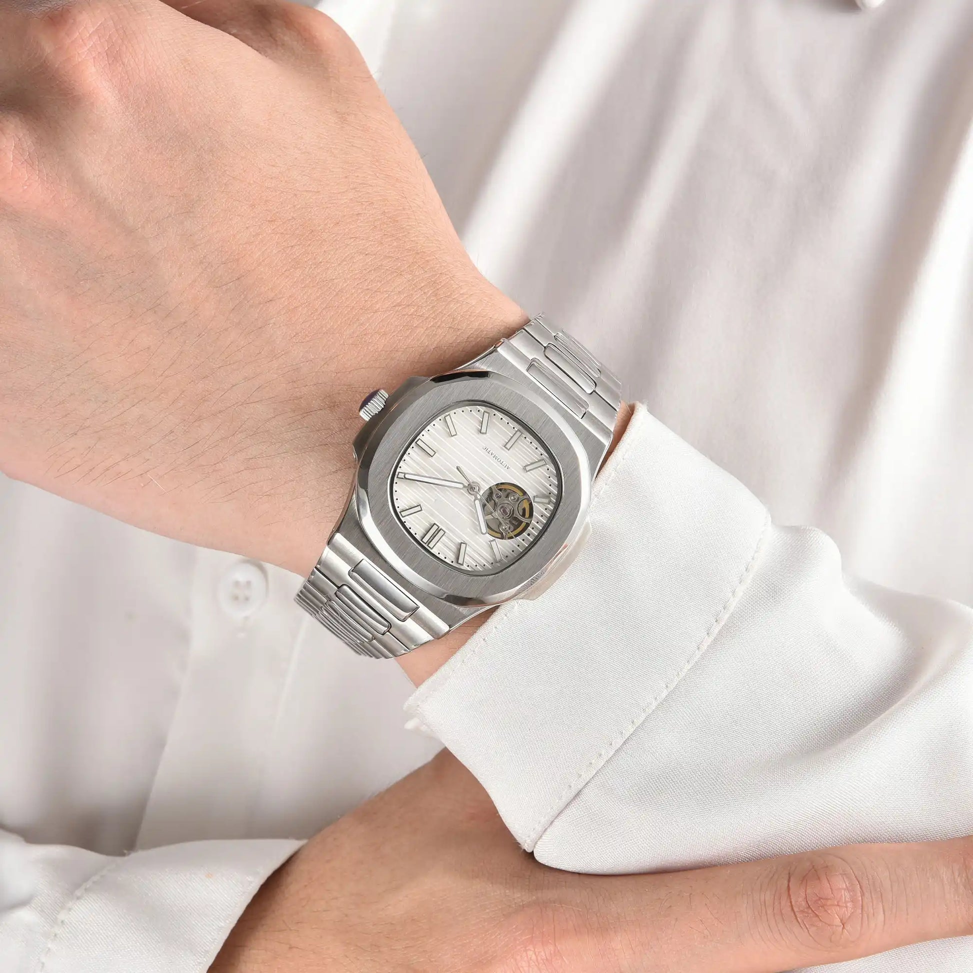 Open heart white Nautilus style Seiko mod watch with stainless steel bracelet on wrist, business lifestyle shot