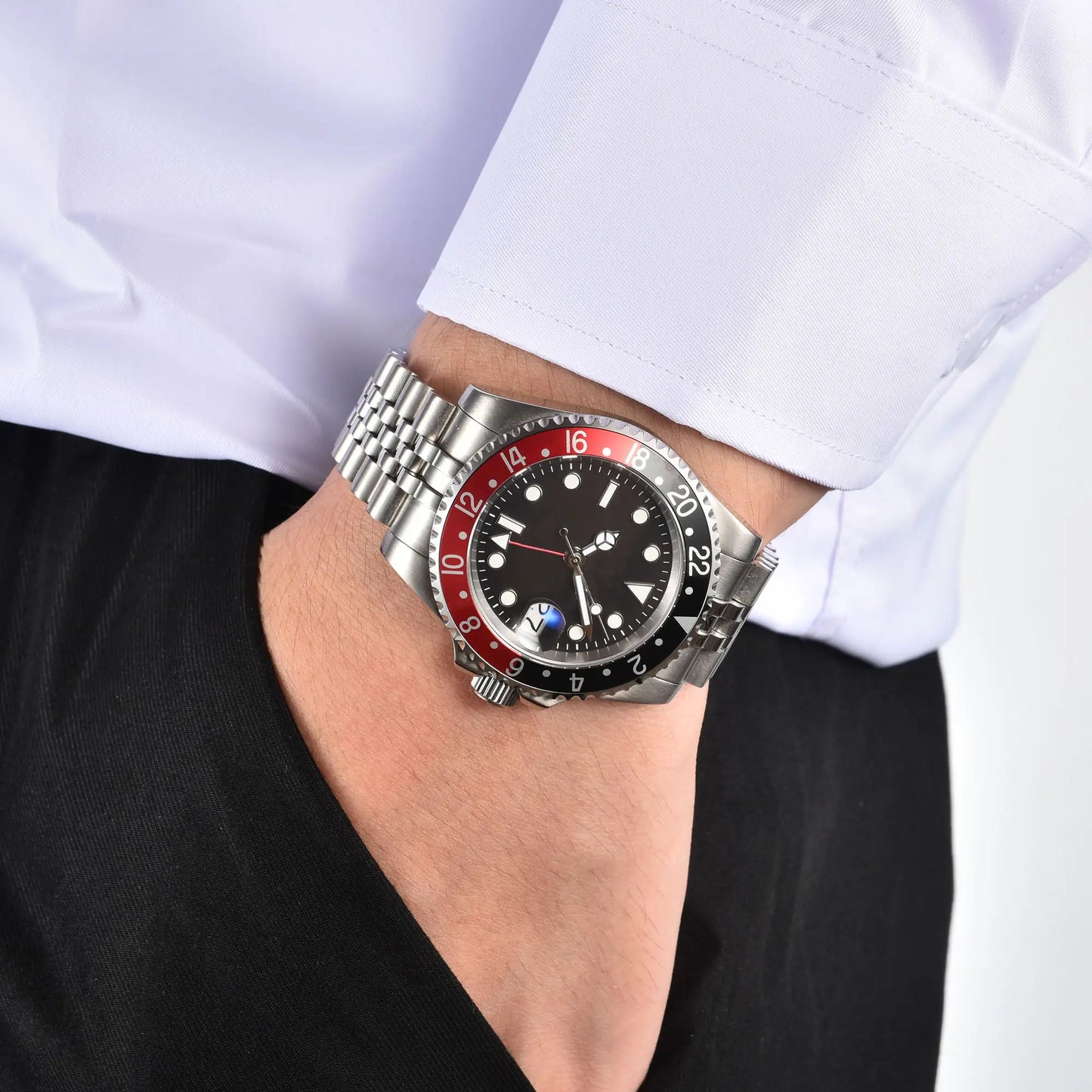 Wrist shot of custom Seiko mod Cola GMT watch worn with a formal suit, showcasing the polished finish and refined dial details