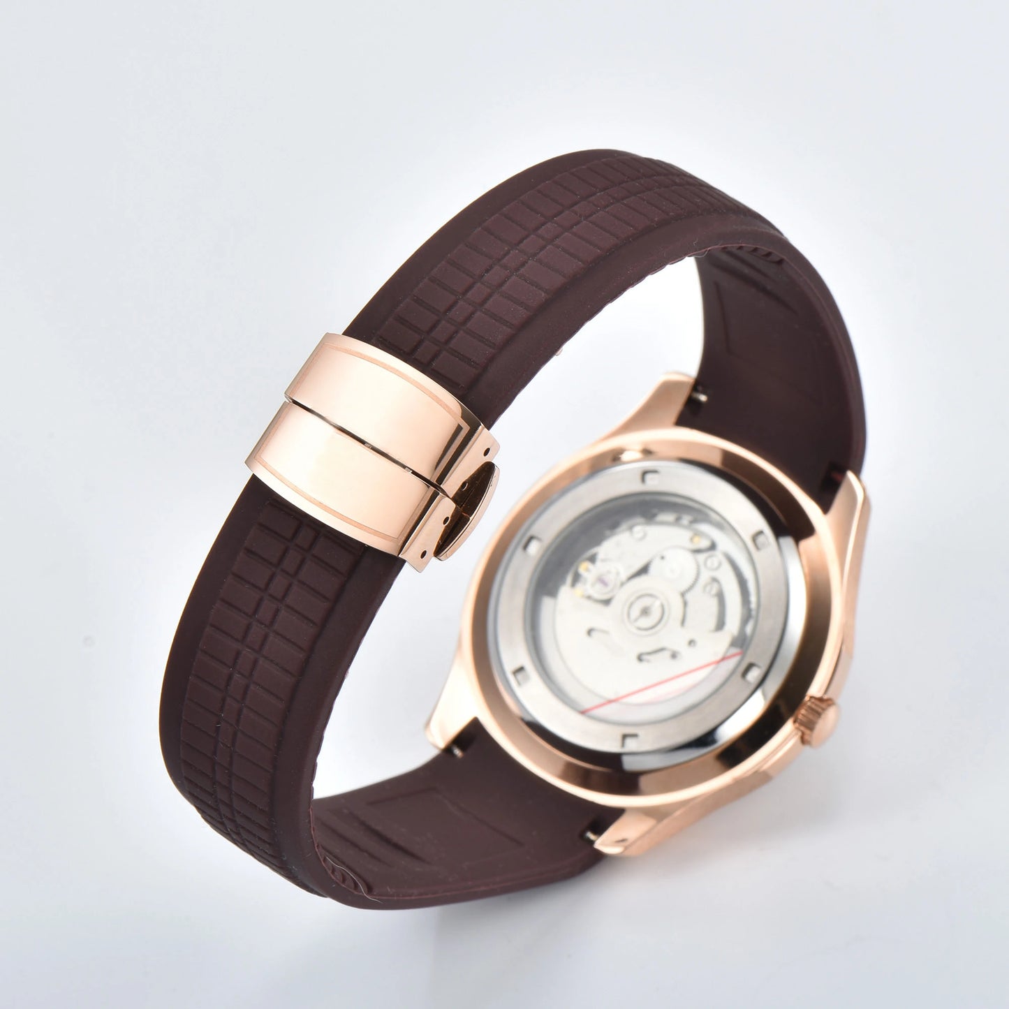 Transparent case back and deployment clasp of rose gold Aquanaut style Seiko mod watch with brown rubber strap