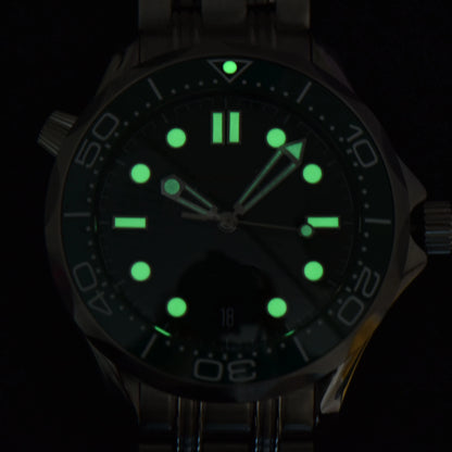 Luminous green dial and hands of Seamaster style Seiko mod diver watch in dark environment
