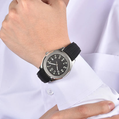 Silver Aquanaut style Seiko mod watch with black rubber strap on wrist, business lifestyle shot