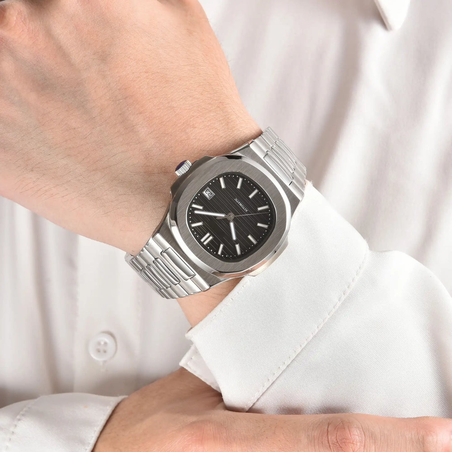 Black dial Nautilus style Seiko mod watch with stainless steel bracelet on wrist, business lifestyle shot