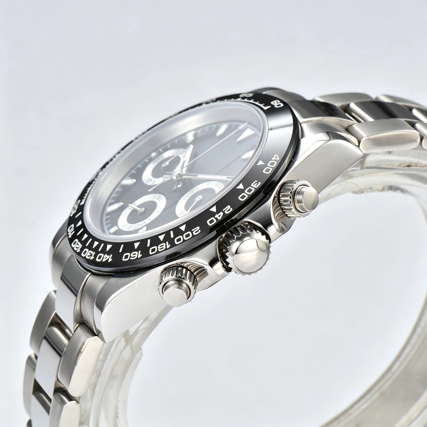 Side view of black bezel Daytona style Seiko mod watch, stainless steel chronograph pushers detail
