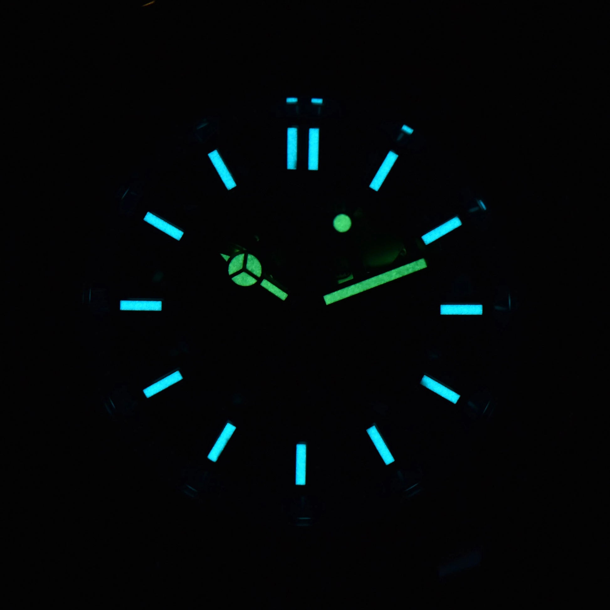 Luminous blue-green dial and hands of skeleton Aquanaut style Seiko mod watch in dark environment