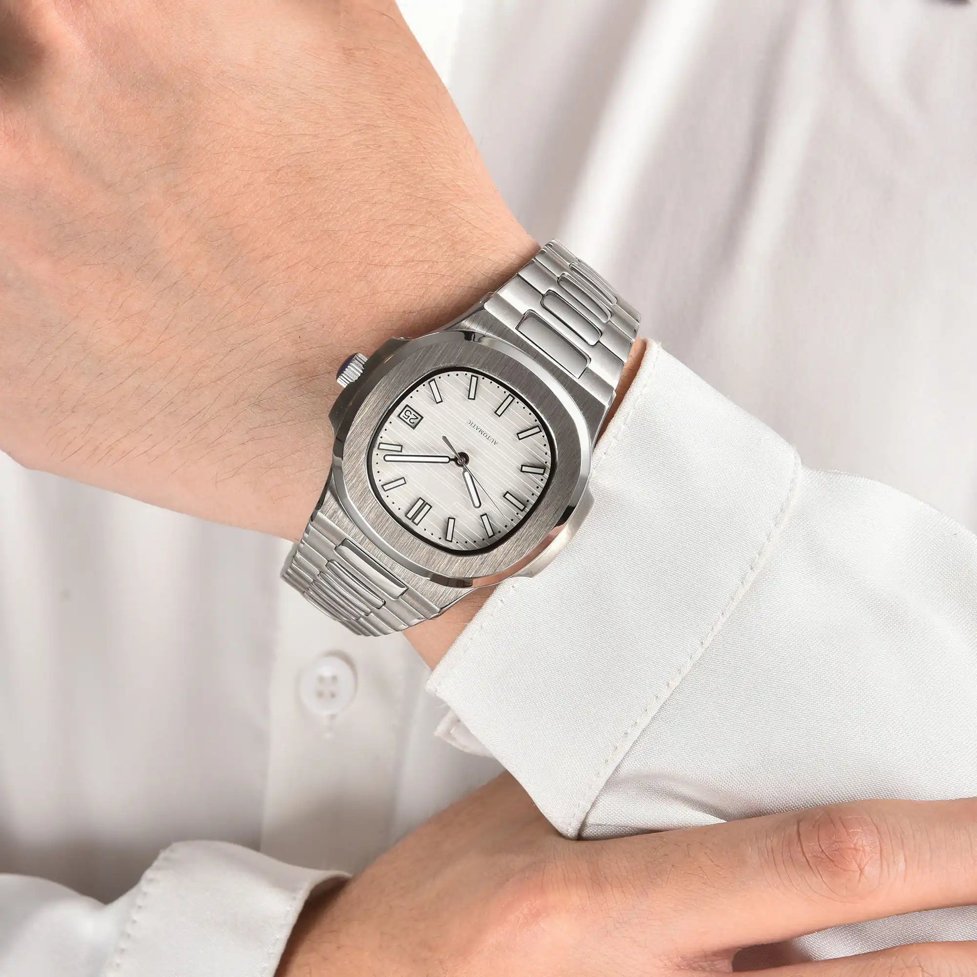 White dial Nautilus style Seiko mod watch with stainless steel bracelet on wrist, business lifestyle shot